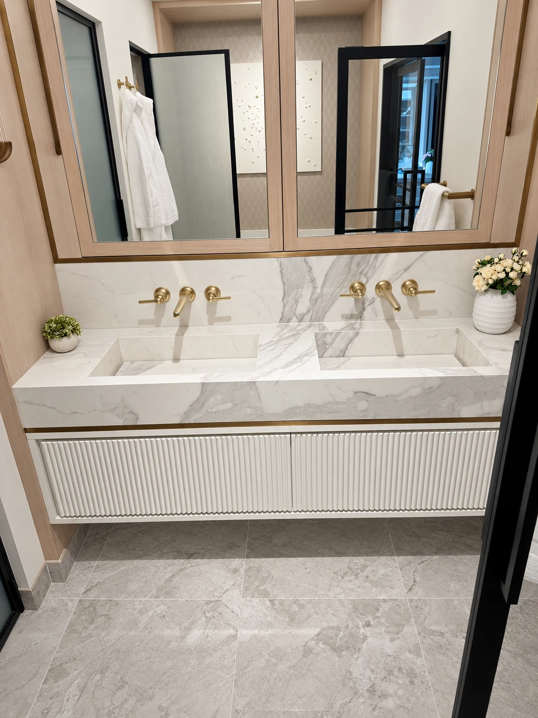 Bespoke twin basins with brass wall taps, fluted vanity and timber-framed mirrors
